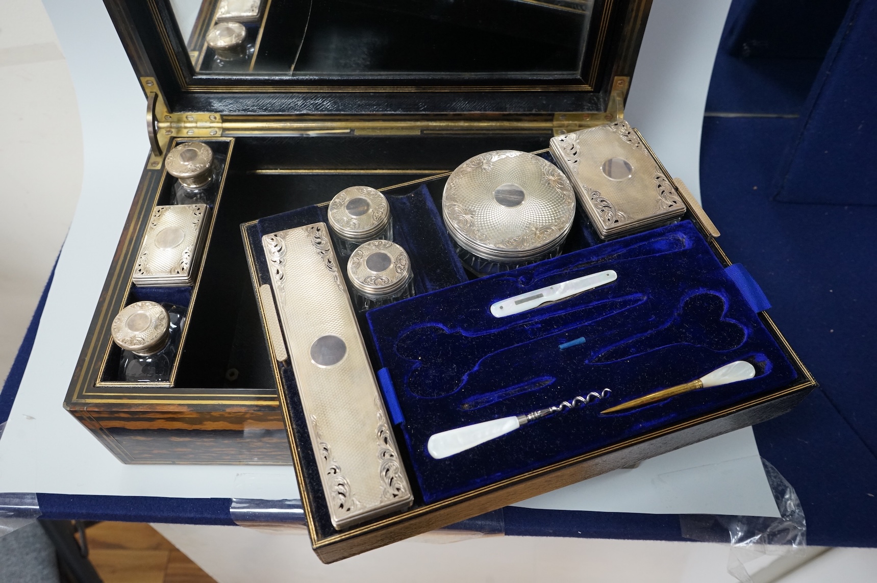 A Victorian brass mounted coromandel wood toilet box by Lund, 57 Cornhill, London, containing eight silver mounted glass toilet jars, six hallmarked for Thomas Johnson I, London, 1865 and three associated? mother of pear